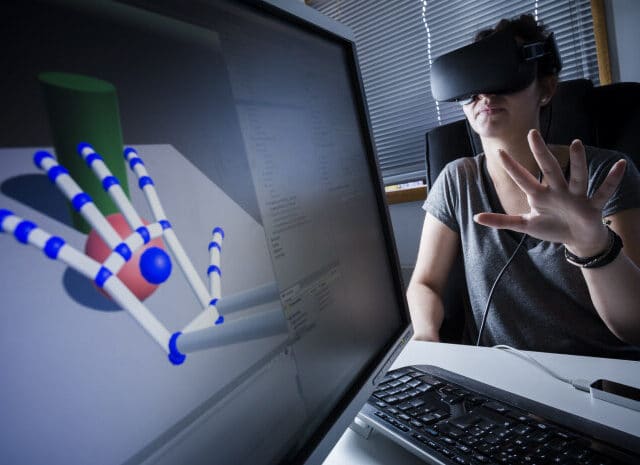 Etudiant qui anime une main sur un écran via son casque VR
